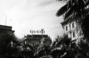 Vintage black and white photo of Gucci building in Milan with palm trees.